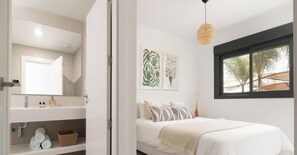 A bedroom with a bed, a window, a mirror, and artwork on the wall. - Casa Banzu | Pool - Terrace - Gym (Mijas)