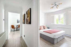 Ein modernes Schlafzimmer mit Bett, Deckenventilator und Blick ins Freie.
