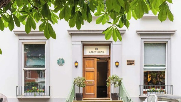 A building with a sign reading 'Abbey Road' at the entrance, a staircase leading up to the door, and a car parked in front. - 1-Bed & Patio - 2 Min Walk to Abbey Road Studios (Greater London)