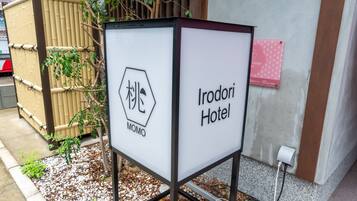 A sign for Irodori Hotel with a logo and name.