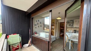 Una stanza con un letto, una finestra e vista sulla cucina.