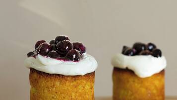 Two cupcakes on a golden stand with a white base.