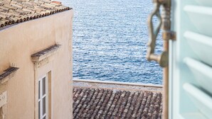 A coastal view from a building with a tiled roof and a window.