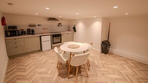 Una cocina compacta con comedor, horno pequeño y cafetera.