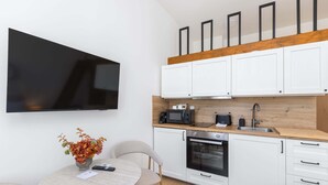 A modern kitchen with white cabinets, a microwave, a toaster, and a sink. - Lovely studio in the center city (Hlavní město Praha)