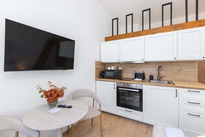 Eine moderne Küche mit weißen Schränken, einer Mikrowelle, einem Toaster und einem Spülbecken.