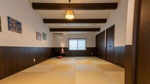 Un pasillo con suelo de tatami, paredes de madera y una lámpara colgante.