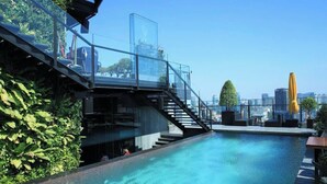 A rooftop pool with glass railings, a staircase, and outdoor seating. - Tracy Ben Thanh Tower  (Ho Chi Minh City)