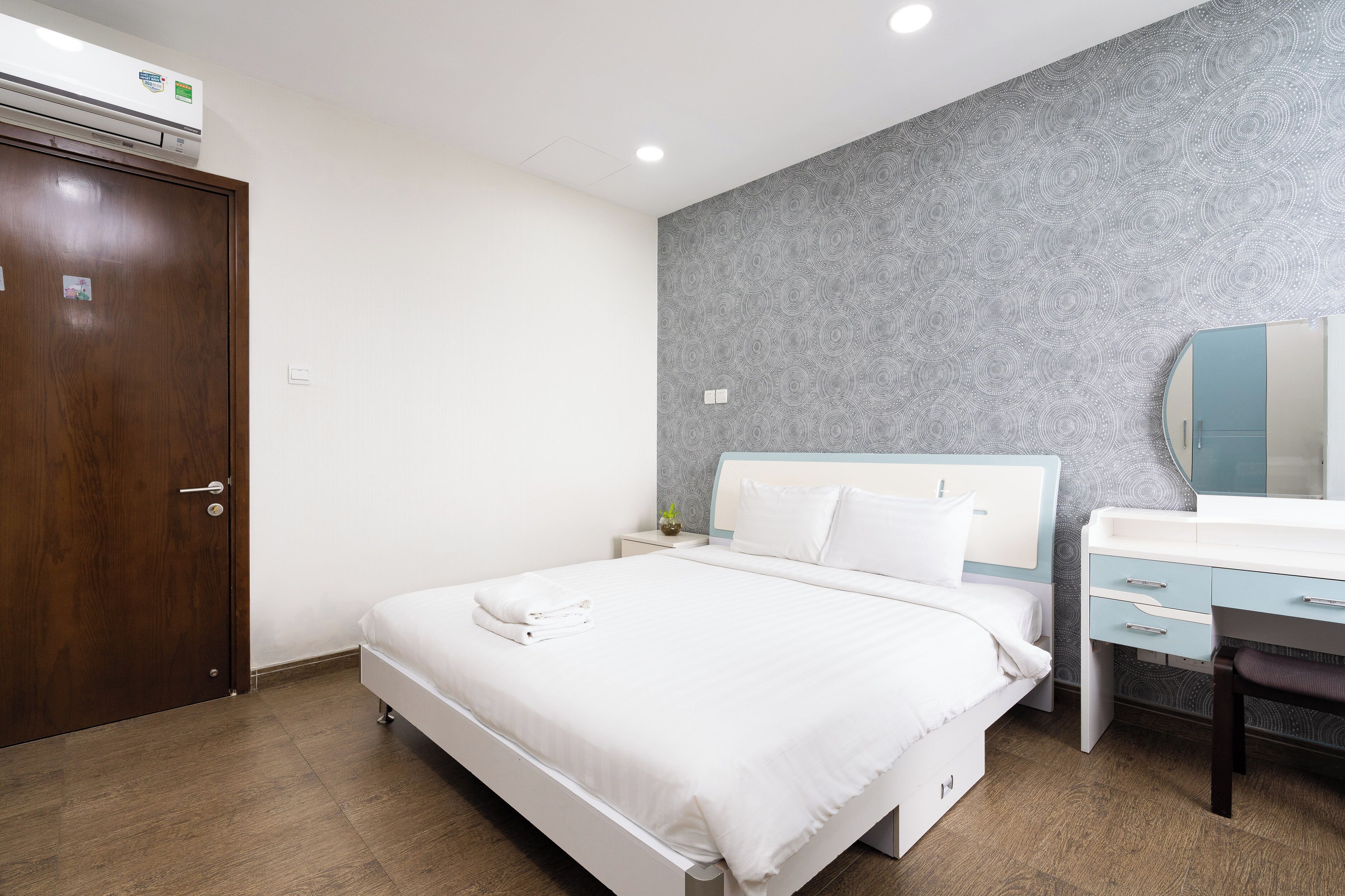 Une chambre à coucher comprenant un lit, un bureau, une chaise, une armoire et un appareil de climatisation.