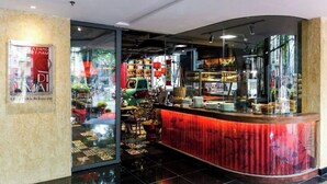 A modern interior with a curved counter, glass doors, and a view of the street outside. - Tracy Ben Thanh Tower  (Ho Chi Minh City)