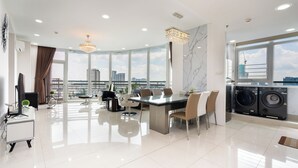A modern kitchen with a large island, a dining area with a glass table, and a view of the cityscape. - Tracy Ben Thanh Tower  (Ho Chi Minh City)