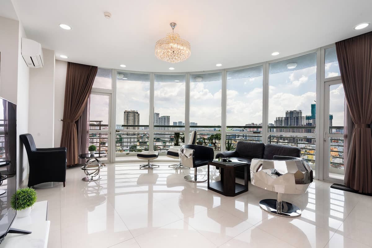 A modern living room with a city view, large windows, and contemporary furniture.