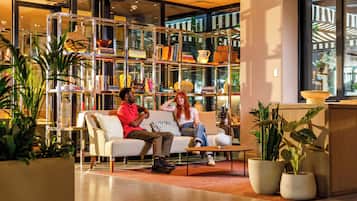 Een modern interieur met een bank, een bijzettafeltje en een boekenplank vol boeken en decoratieve objecten.