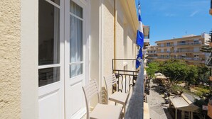 A building with a balcony, white chairs, and a flag. - Kismet Urban Boutique (Heraklion)