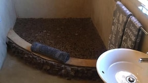 Kylpyhuone, jossa on suihku, pesuallas ja pyyheteline.
