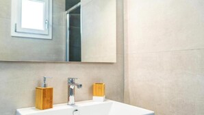 A bathroom with a white sink, two wooden soap dispensers, a chrome faucet, and a mirror above the sink. - Resort Beach San Gemiliano (Arbatax)