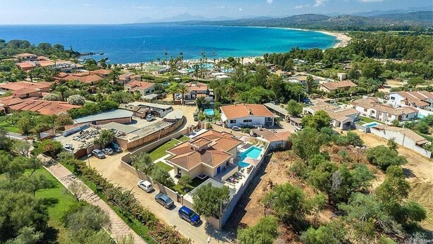 An aerial view of a coastal residential area with houses, a swimming pool, and a beach. - Resort Beach San Gemiliano (Arbatax)