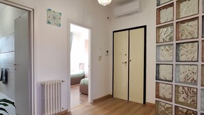 A hallway with a radiator, a sliding door, and a wall with abstract art. - Casa Puccini - Cozy 2-bedroom Florentine home (Florence)