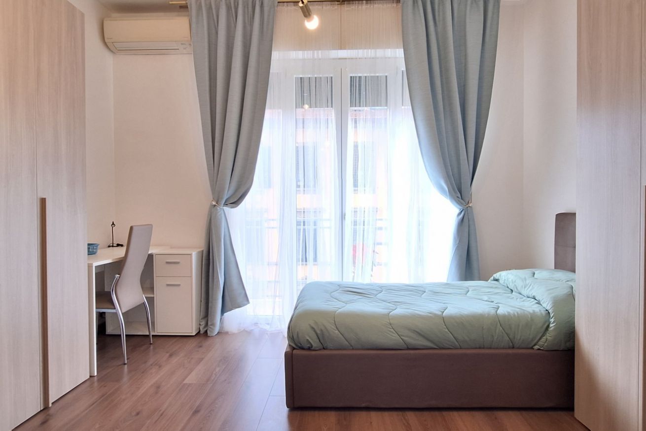Ein Schlafzimmer mit einem Bett, einem Schreibtisch und einem Stuhl.