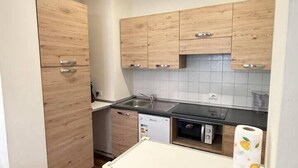 Una cucina compatta con mobili in legno, una lavastoviglie e un piano di lavoro.