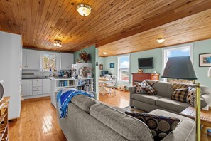 A cozy living room with a sofa, a coffee table, and a television. - Brigus Cottage  Parking, Fire Pit & Garden (Brigus)