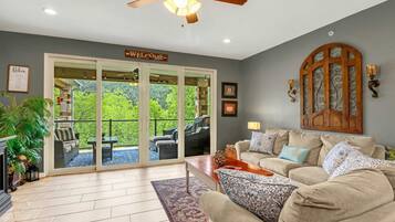 A living room with a sofa, coffee table, and a ceiling fan. There is a sliding glass door leading to an outdoor patio area.