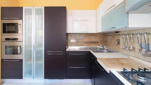 Una cocina moderna con electrodomésticos de acero inoxidable, un lavamanos doble y una estufa a gas.