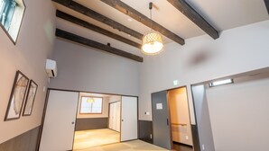 A hotel room with a large window, a ceiling fan, and a door leading to another room. - Irodori Hotel SORA (fukuokashi,hakataku,minoshima)