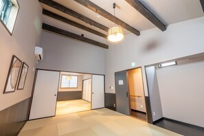 A hotel room with a large window, a ceiling fan, and a door leading to another room. - Irodori Hotel SORA (fukuokashi,hakataku,minoshima)