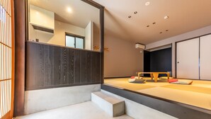 A room with tatami flooring, a low wooden bench, a small step leading to a tatami mat, and a sliding door. - Irodori Hotel SORA (fukuokashi,hakataku,minoshima)