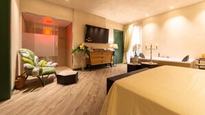 A hotel room with a bed, a desk, a chair, a dresser, a TV, and a bathroom. - B&B Relax Assoluto - Luxury Urban Spa (Casalbordino)