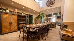 A spacious dining area with a long table, multiple chairs, and a clock on the wall. - B&B Relax Assoluto - Luxury Urban Spa (Casalbordino)