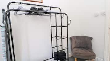 A bunk bed with a metal frame, a grey upholstered chair, and a small ottoman.