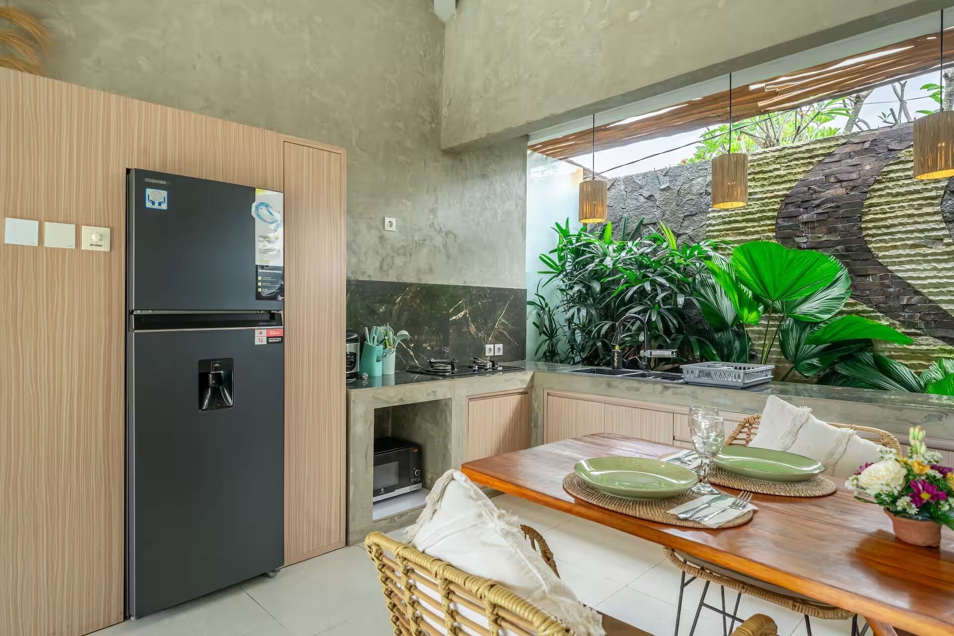 Une cuisine moderne équipée d’un réfrigérateur, d’une cuisinière et d’une table à manger pour deux personnes.