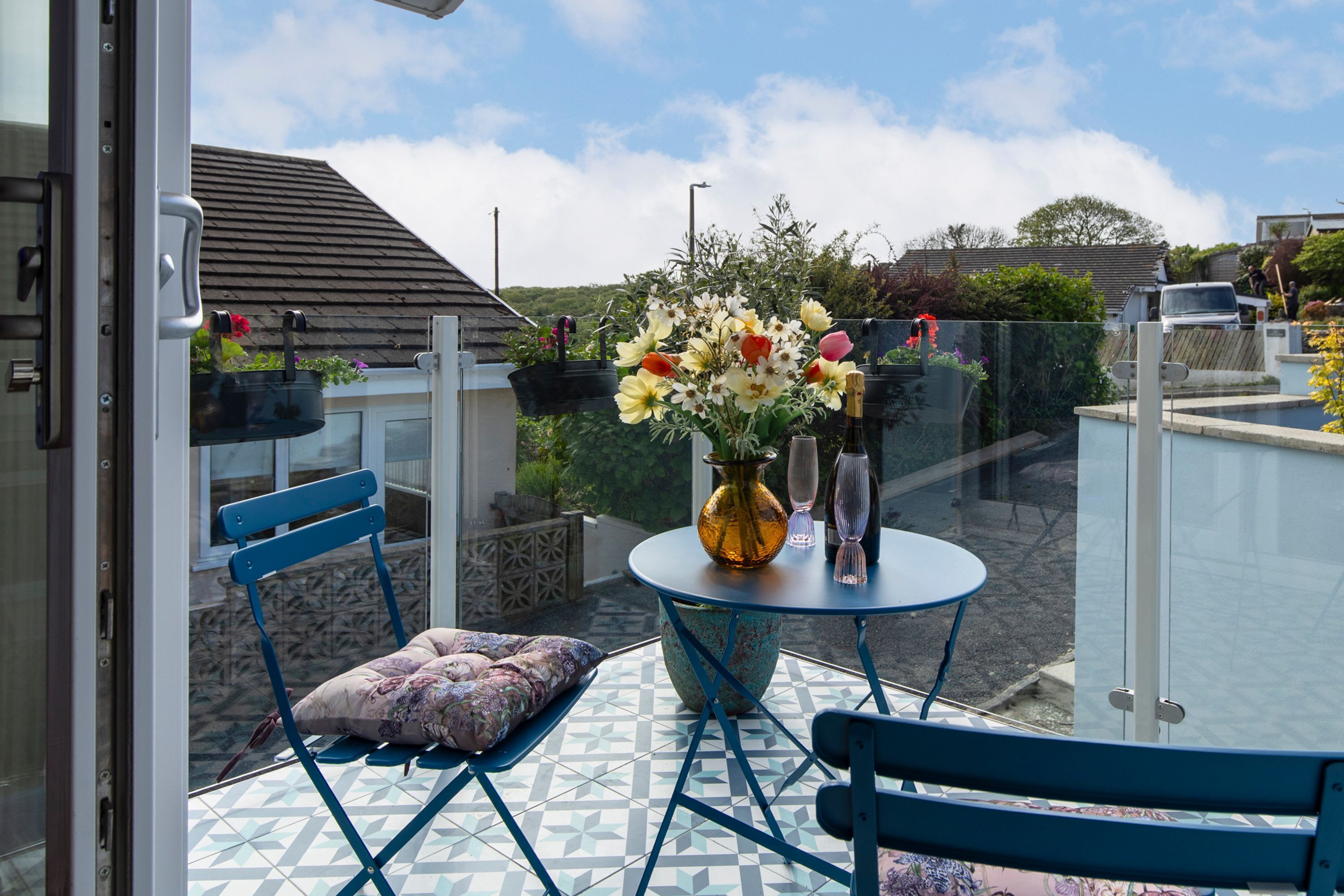 Ein Balkon mit Tisch, Stühlen und einem Blumenstrauß.