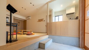 Un interno moderno con una scala, una panca di legno e una lampada da terra nera.