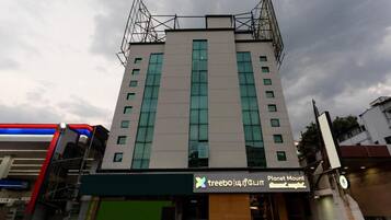 A multi-story building with a flat facade, large windows, and a sign for 'treebo | 4th & 5th'.