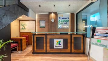 En receptionsdisk med en logotyp för ”treebo”, en klocka och en skylt med texten: ”DET ÄR ALLTID EN BRA DAG PÅ treebo”.