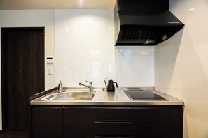 A modern kitchen with a sink, stove, and cabinets. - Irodori Hotel SUI (fukuokashi,hakataku,taihakumachi)