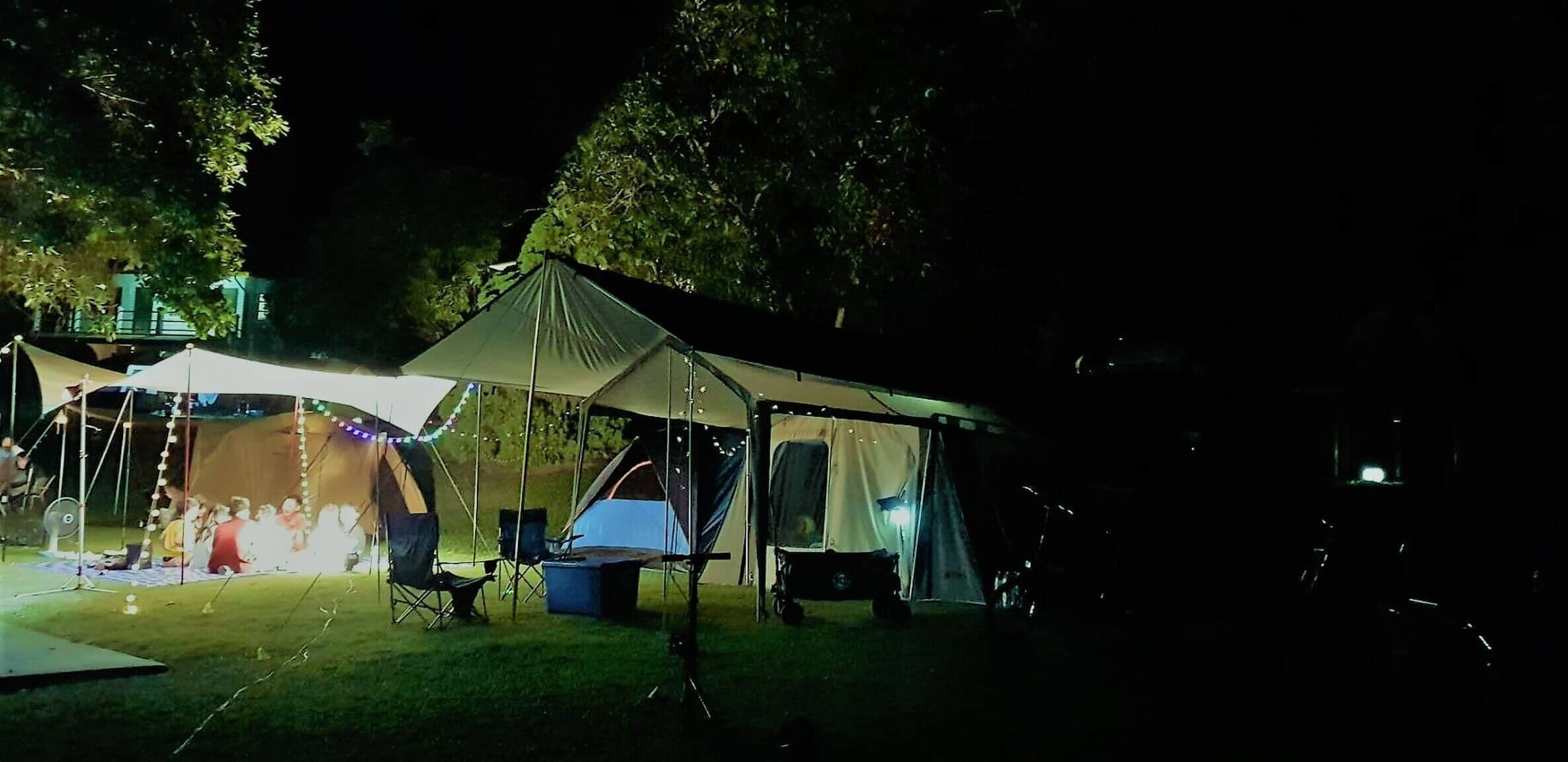 En campingplads med telte og campingstole.
