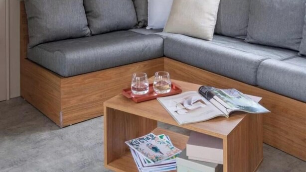 A modern living room with a grey sectional sofa, wooden coffee table, and floating shelves with decorative items. - Pocket" mobile home in the heart of the pony club (Hostens)