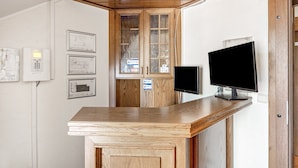 A reception desk with a flat-screen TV, wooden cabinets, and framed architectural plans on the wall. - Zimmer „Doppelzimmer 11“ mit WLAN (Rhede)