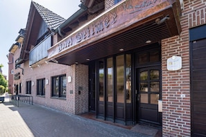 A brick building with a storefront and a black door.
