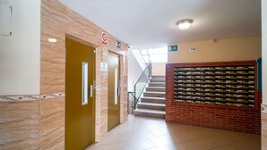A hallway with a staircase, a door with a sign, and a wall with a display of items. - Albaida II 2B Torrecilla Beach Casasol (Nerja)