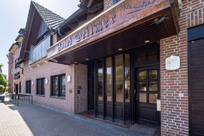 A brick building with a storefront and a black door. - Zimmer „Doppelzimmer 14“ mit WLAN (Rhede)