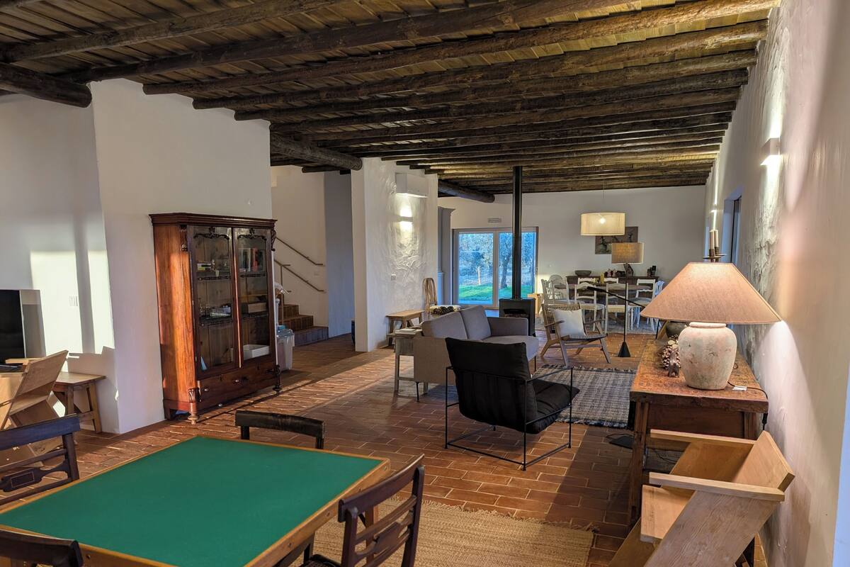 Un vaste espace de vie comprenant une table de billard, des meubles en bois et un plafond au style rustique.