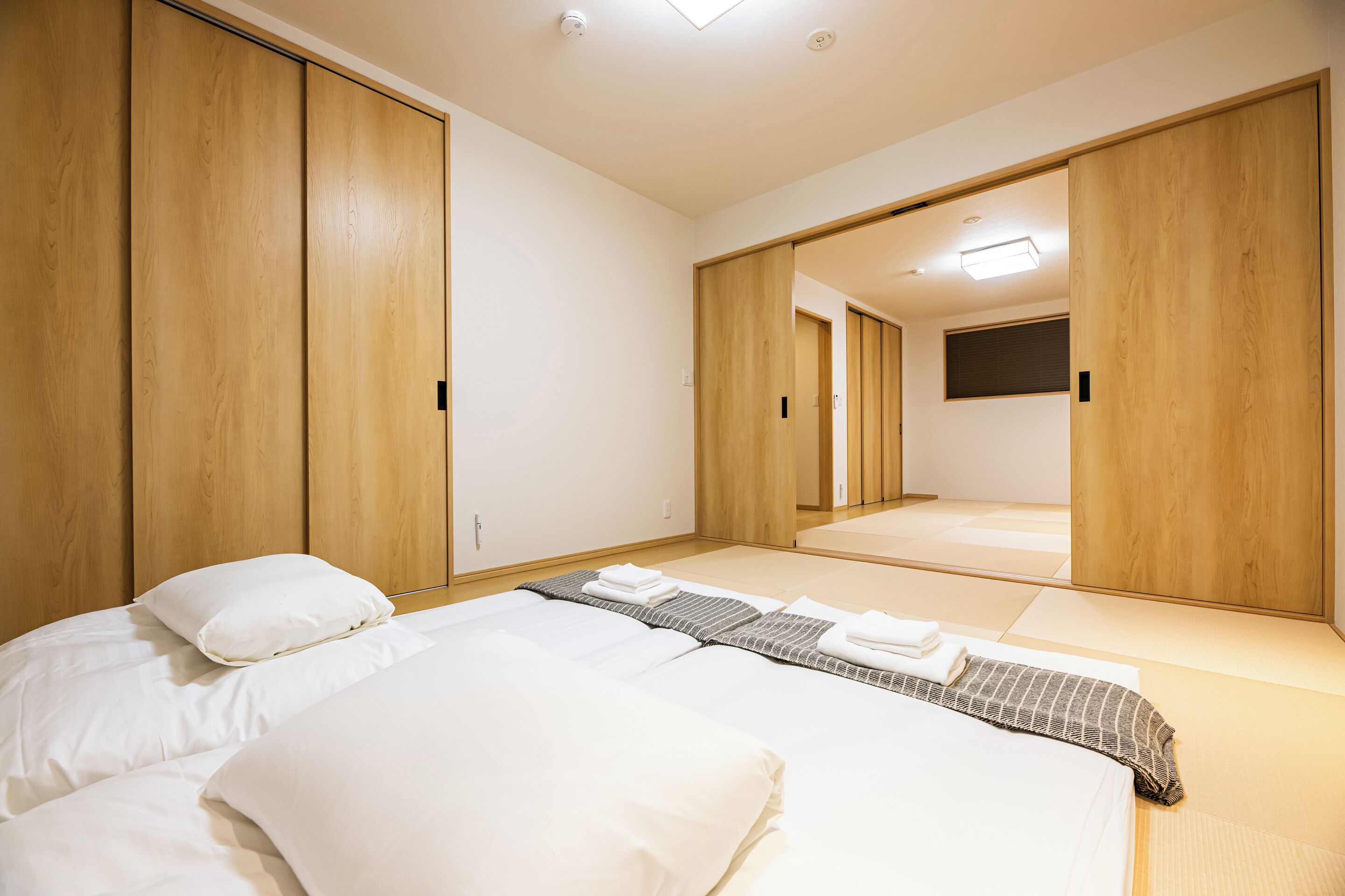 A hotel room with a bed, a wardrobe, and a mirror.