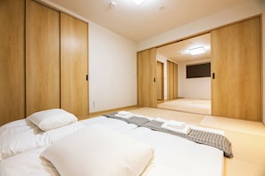 A hotel room with a bed, a wardrobe, and a mirror. - Irodori Hotel KOU (fukuokashi,hakataku,taihakumachi)