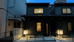 A building with a dark facade, a visible entrance, and a signboard. - Irodori Hotel KOU (fukuokashi,hakataku,taihakumachi)