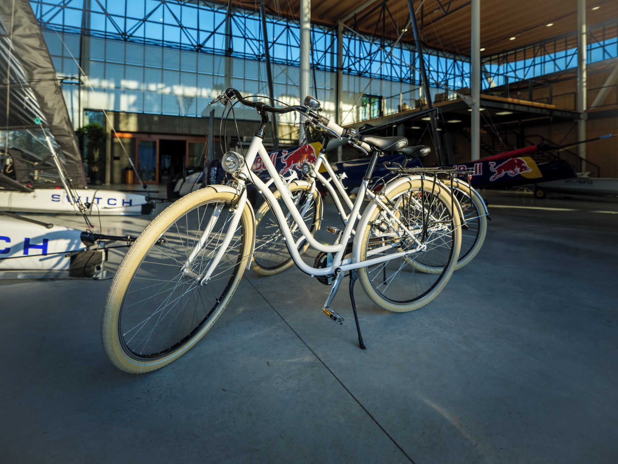 A bicycle parked indoors with a modern building in the background.